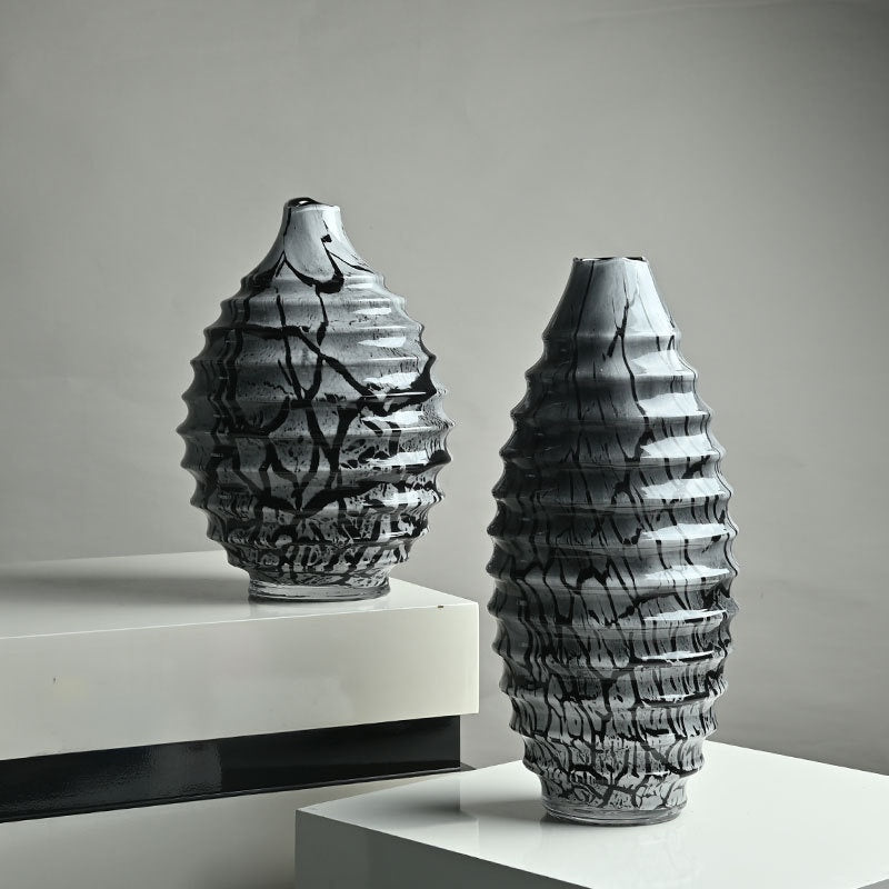 Black and white marbled glass ribbed vase set on white table