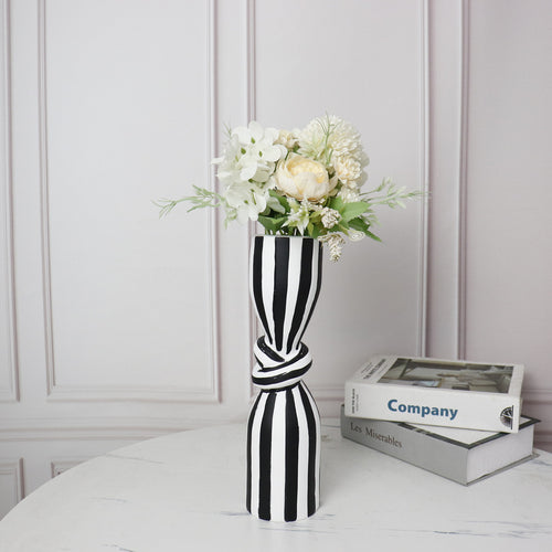 Set of two knotted striped vases on table