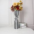 Large striped resin vase with floral arrangement