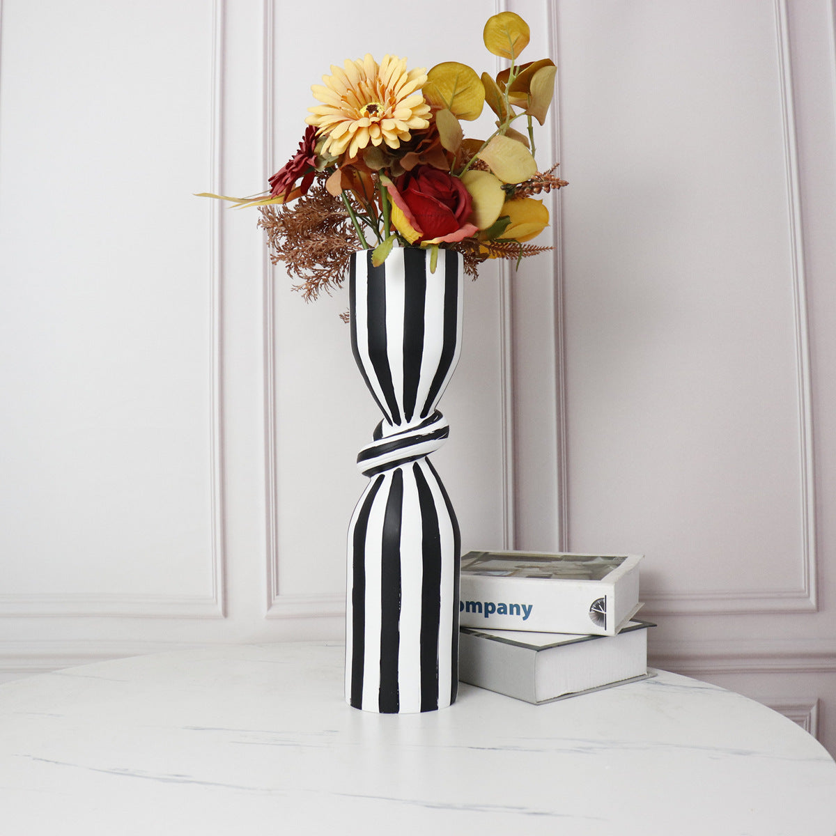 Large striped resin vase with floral arrangement