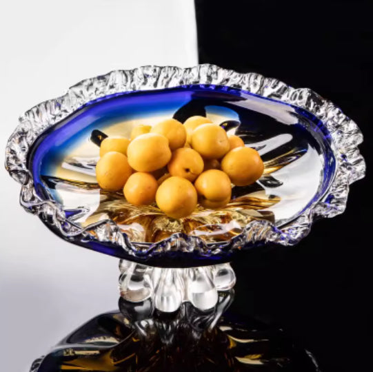 Blue and amber crystal fruit bowl with scalloped rim holding apricots
