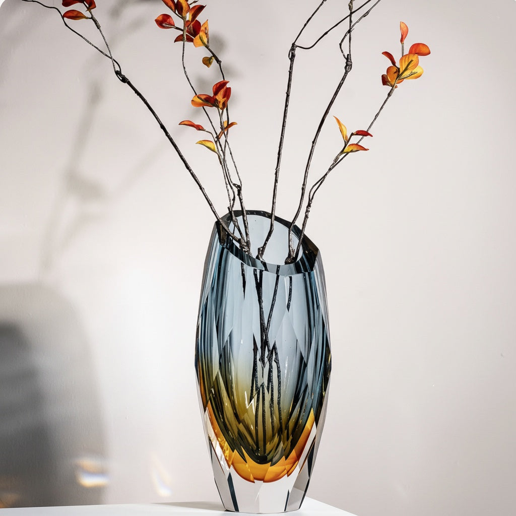 Angled view of blue and amber faceted glass vase with branches