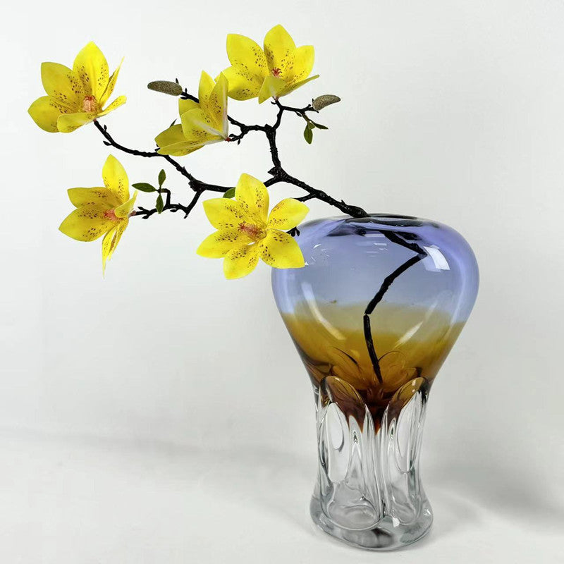 Art glass vase with yellow flowers showing blue and amber gradient