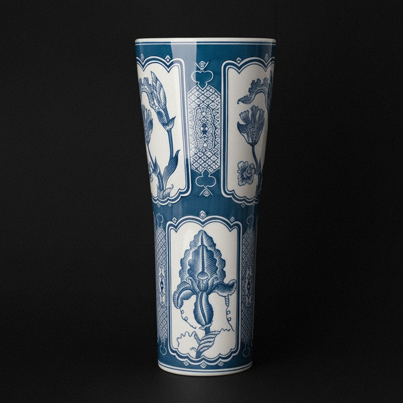 Blue and white ceramic tall flared vase against a dark background