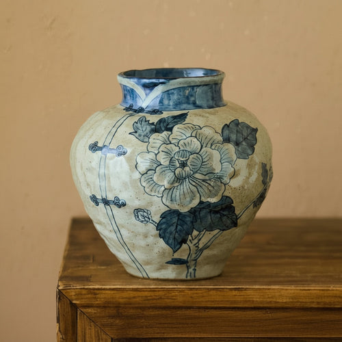 Front view of blue and beige floral ceramic vase with qipao collar detail