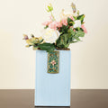 Tall rectangular blue ribbed vase with floral metal accents