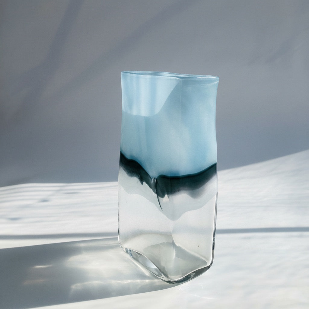 Angled view of blue art glass vase with light reflection