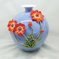 Front view of blue crackle glaze vase with sculpted orange flowers
