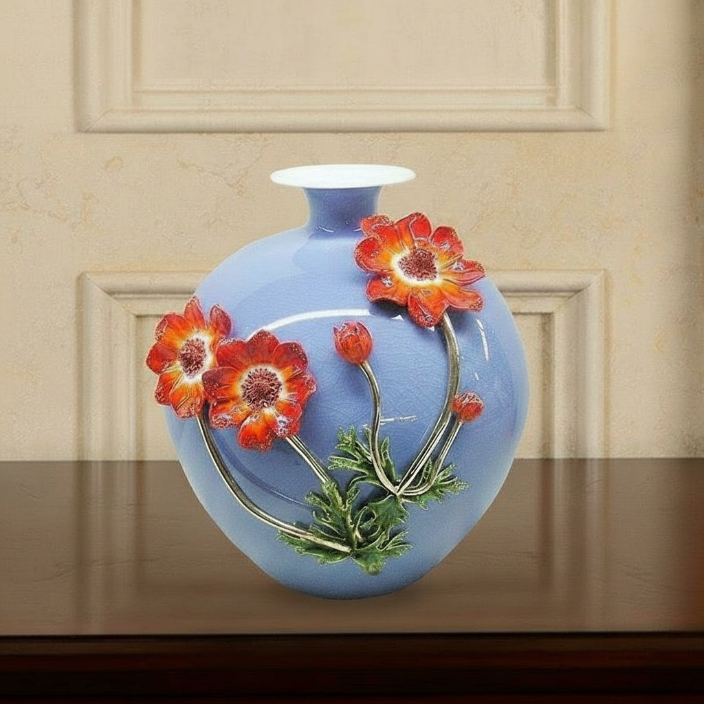 Blue porcelain vase with red flowers displayed on a wooden console table