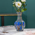 Blue floral ceramic vase with gold ribbing and avian motifs