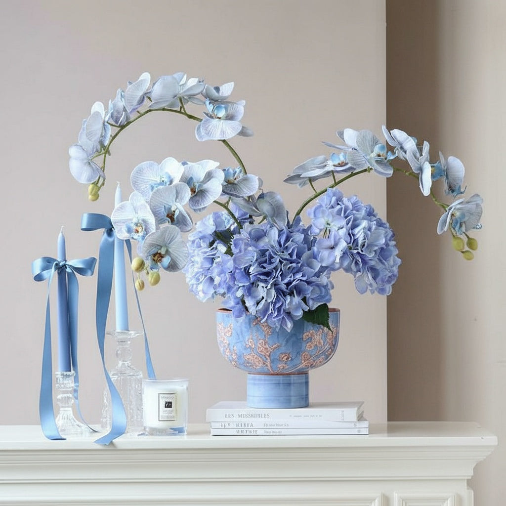 Blue porcelain pedestal vase styled with hydrangeas and candles