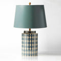 Front view of blue geometric ceramic table lamp with teal shade