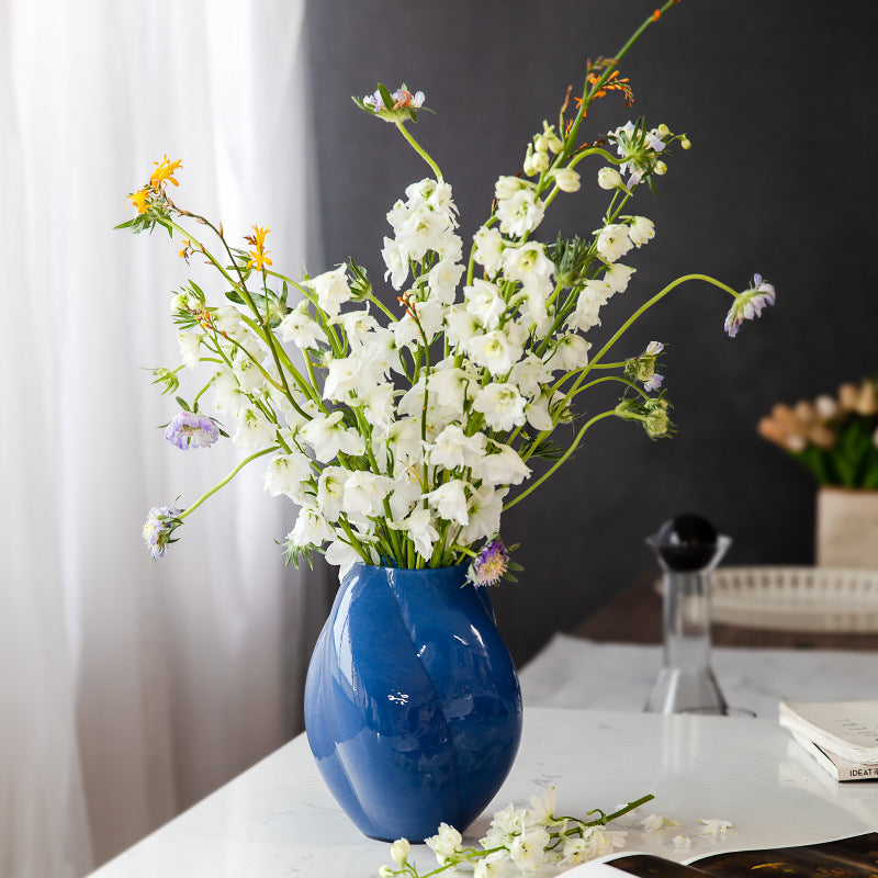 Blue glass spiral fluted vase with white wildflowers