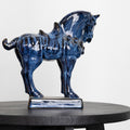 Side profile of blue glazed ceramic horse sculpture on black table