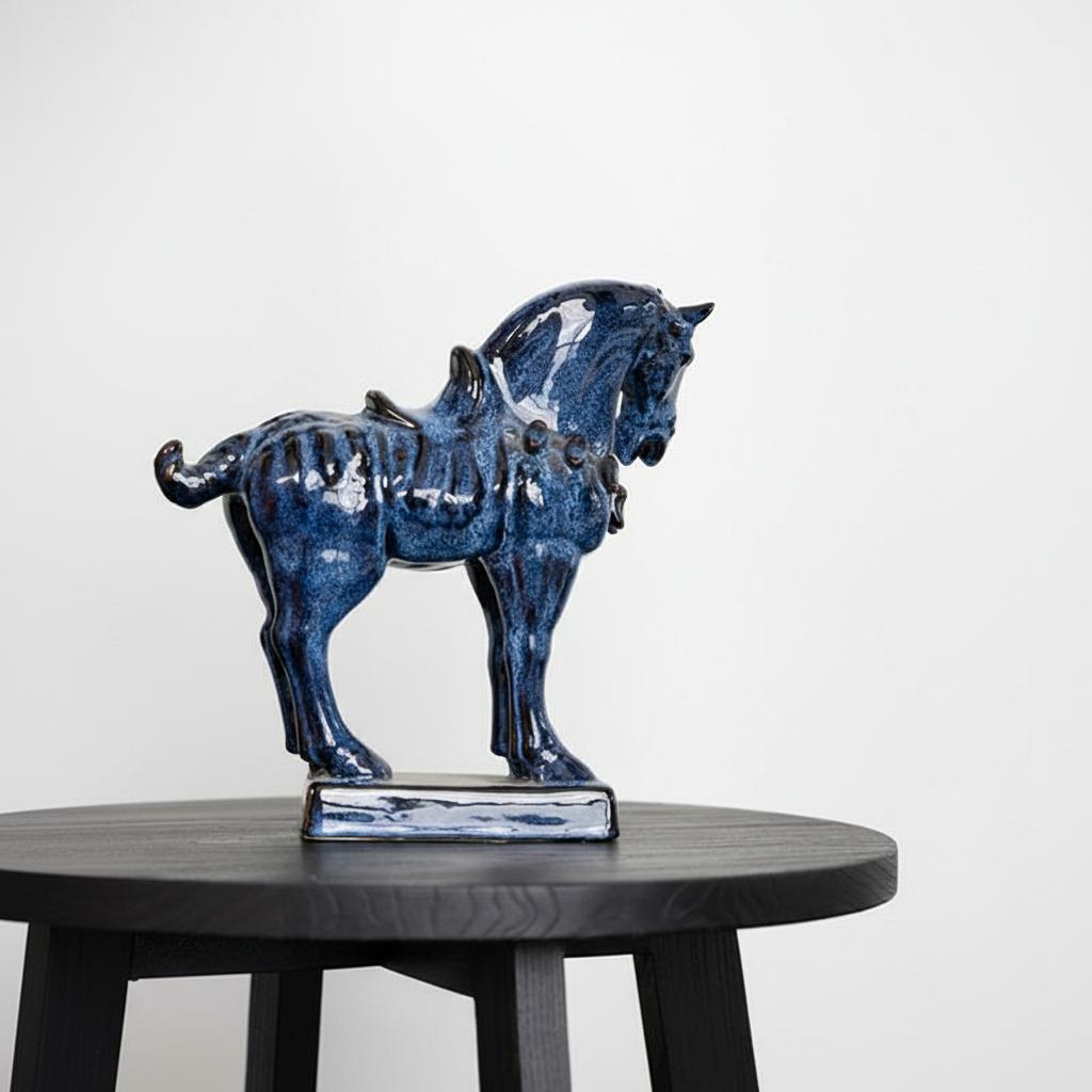 Angled view of blue glazed ceramic horse sculpture showing saddle details