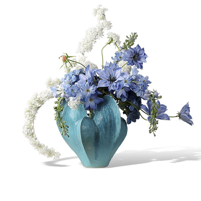 Blue glazed ceramic sculptural vase with floral arrangement