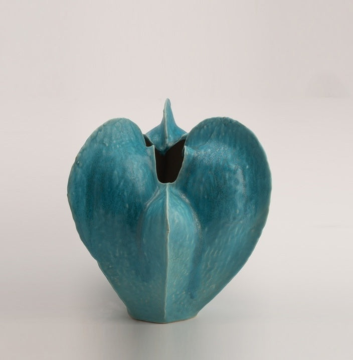 Empty blue glazed ceramic sculptural vase front view