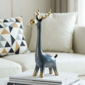 Blue and gold glazed ceramic reindeer sculpture styling on books