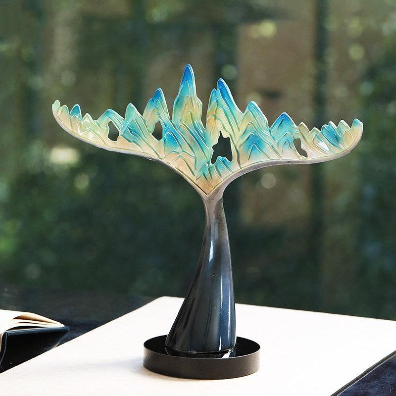 Front view of the blue and gold mountain sculpture on a table