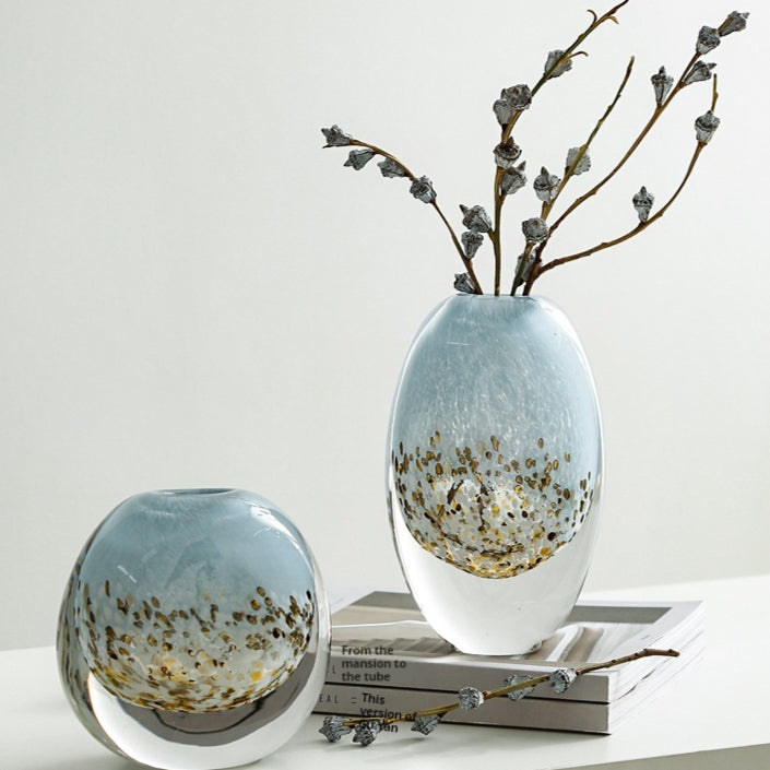 Set of two blue and gold speckled glass vases styled on table