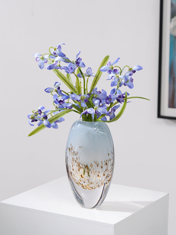 Large blue vase styled with white orchid arrangement