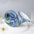 Side view of blue and green swirled glass conch shell sculpture
