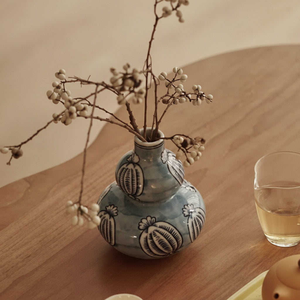 High angle view of blue ceramic vase on wooden table with tea set