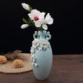 Side view of tall blue ceramic vase with floral texture