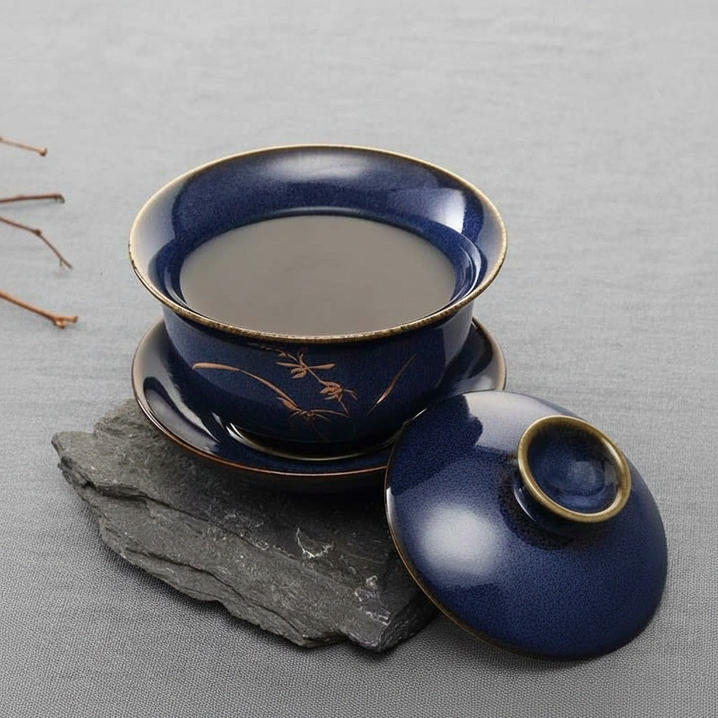 Open blue teacup filled with tea beside lid