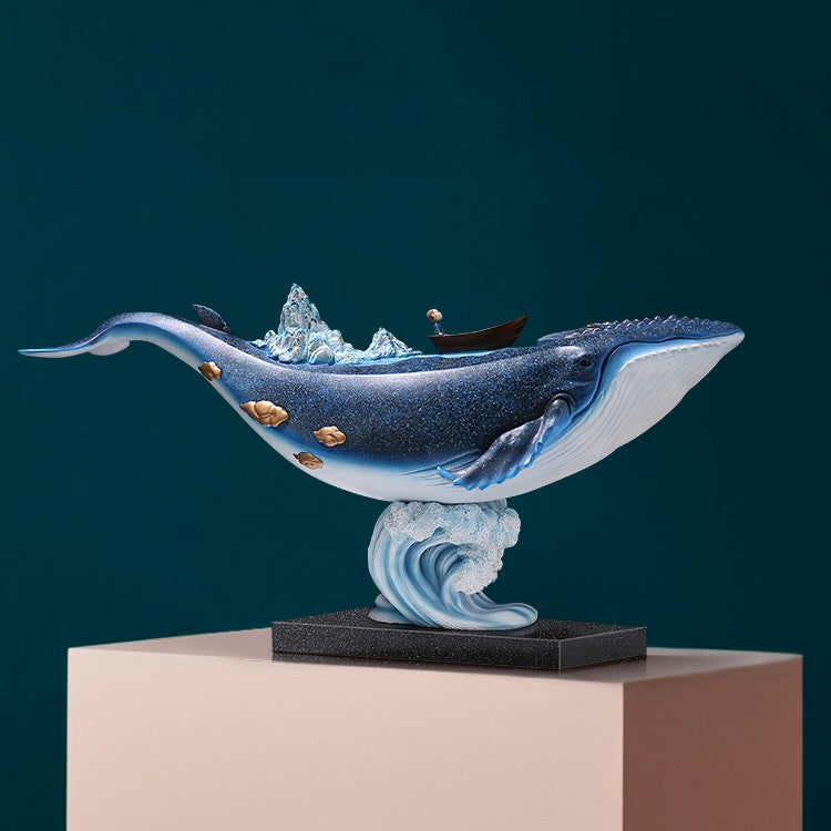 Side view of blue whale sculpture with boat and mountains