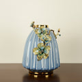 Large blue ceramic vase with green enamel flower and gold base