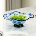 Blue spotted glass fruit bowl with wavy rim and black base