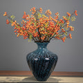 Blue veined patterned ceramic vase with artificial orange berries