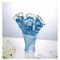 Detail of ruffled rim on blue glass vase