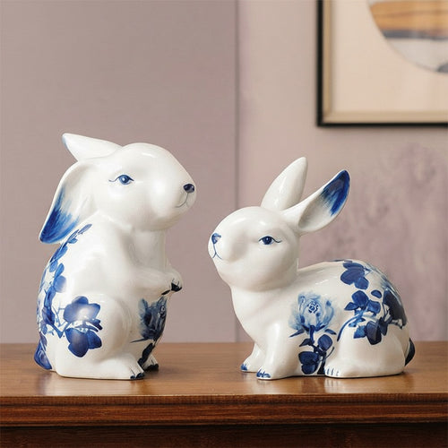 Pair of blue and white ceramic rabbit figurines with floral patterns