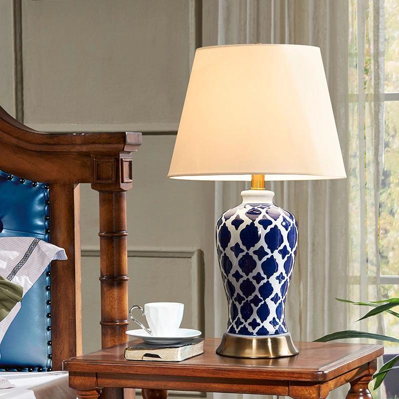 Ceramic table lamp on bedside table with brass base