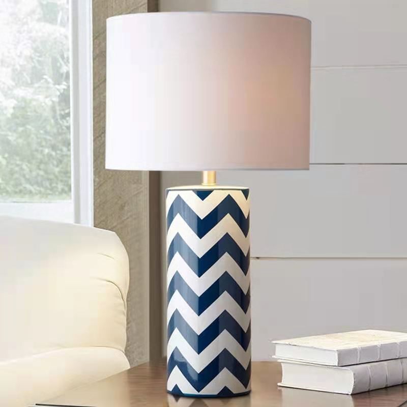 Ceramic chevron lamp on side table in bright living room setting