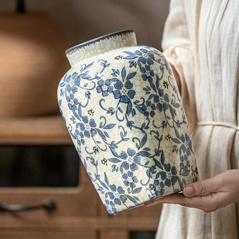 Hands holding large blue and white ceramic vase
