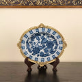 Front view of blue and white ceramic bowl with brass rim on display stand