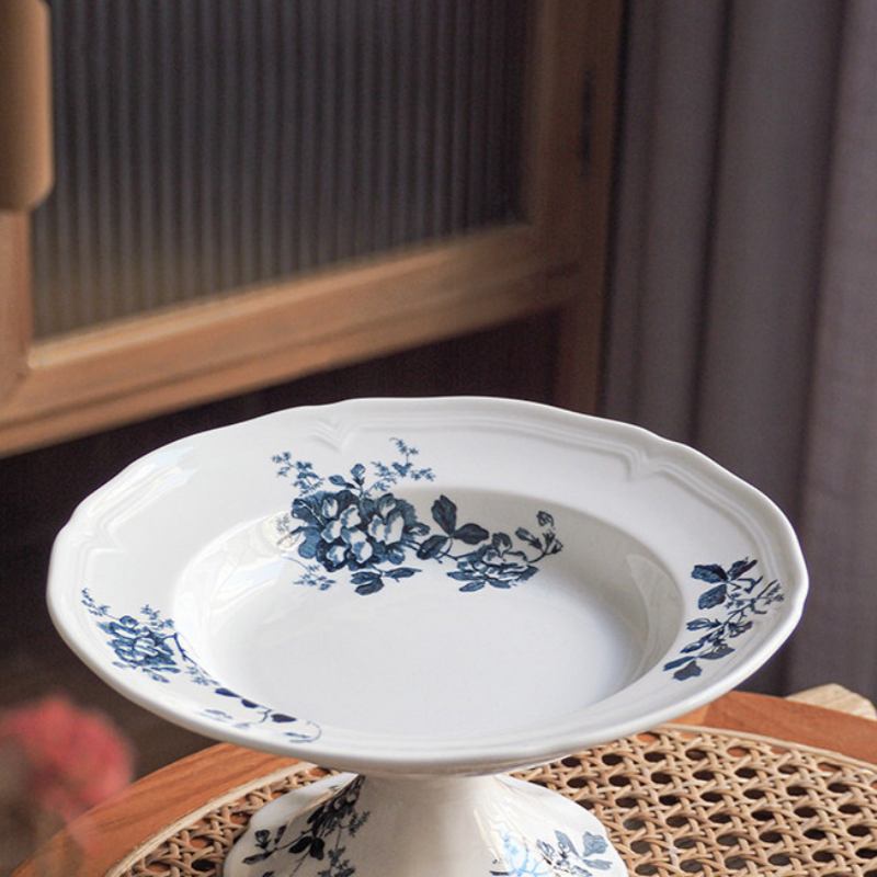 Angled view of scalloped rim ceramic footed bowl