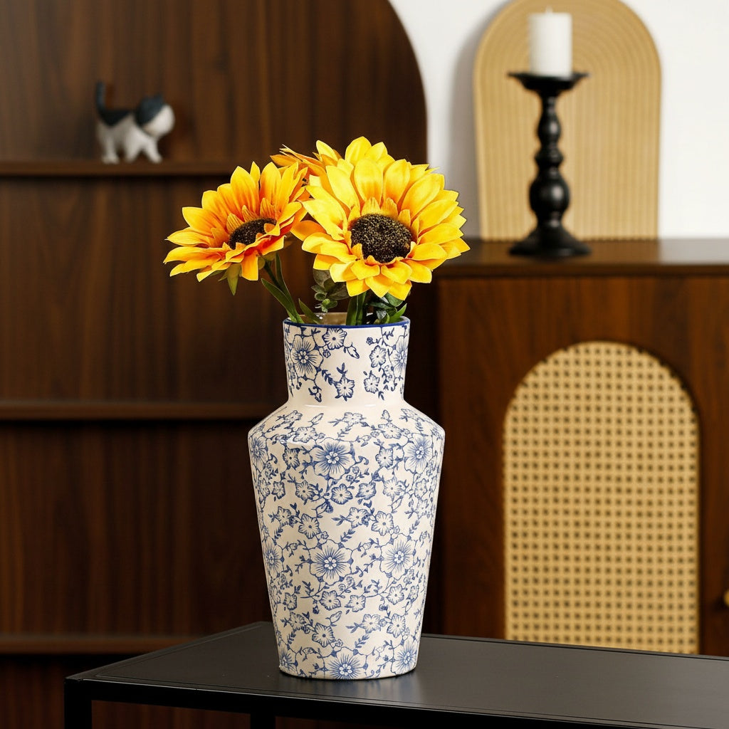 Blue and white floral ceramic tapered vase with sunflowers on a black table