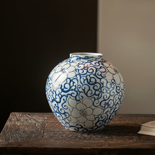 Close up of blue and white ceramic orb vase showing gold detailing