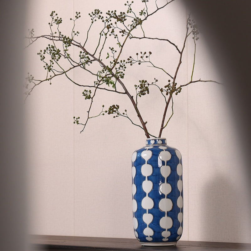 Cylindrical porcelain vase with blue pattern holding branches