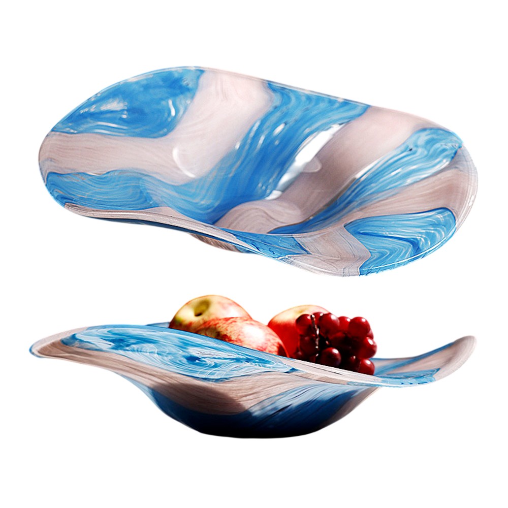 Blue and white marbled glass centerpiece bowl with wavy sculptural form on white background