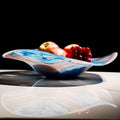 Side view of blue and white marbled glass bowl with fruit