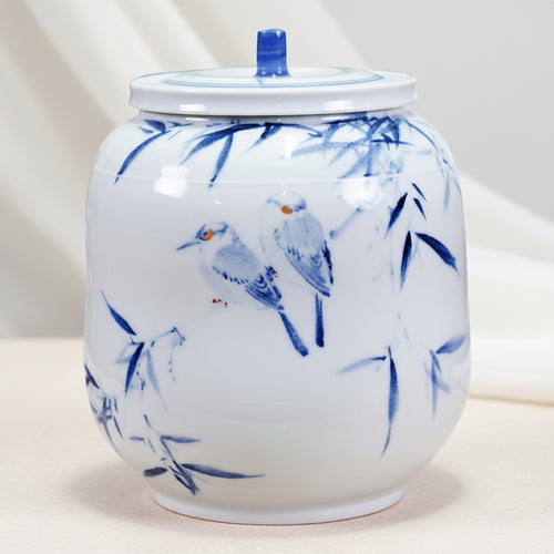 Blue and white porcelain jar with bird motif on white background