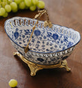 Angled view of blue and white porcelain bowl with brass bird handle