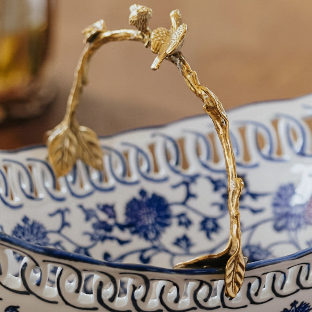 Close up detail of brass bird and branch handle on porcelain bowl