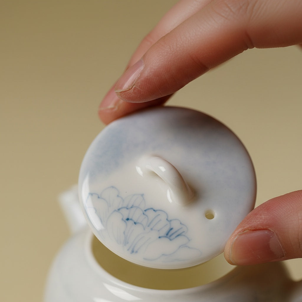 Close-up of teapot lid with hand-painted blue floral design