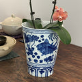Close up of blue and white porcelain vase with fish and lotus motif